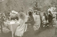  Jenter i barneselskap på Rophaug i 1912-1913. Dei er sessa til bords og får fint brød og bollar og saft i fine koppar. Foto: Miss Law. 