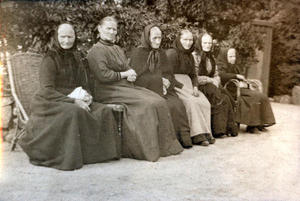Seks eldre kvinner frå Sand på rekke og rad i hagen på Rophaug. Foto: Miss Law. 