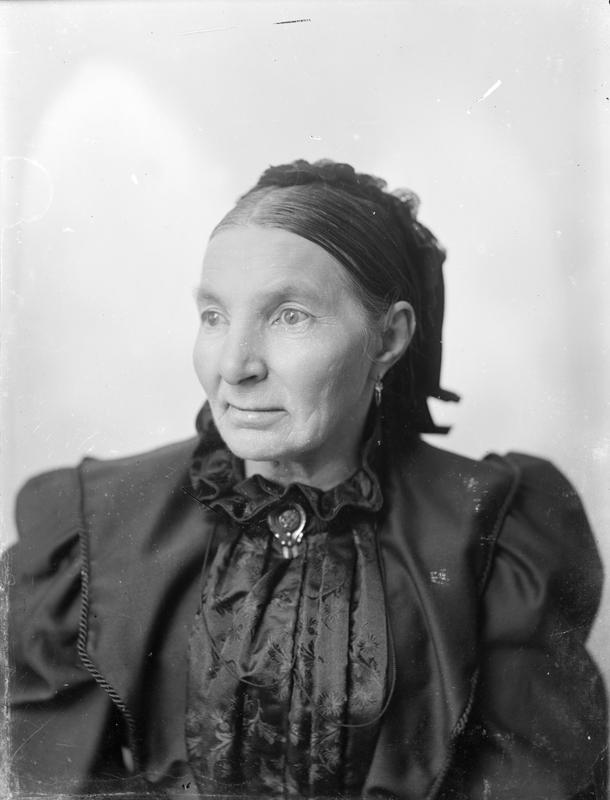 Atelierfotografi av ukjent dame, nærbilde. Fokus er skarp i ansikt og bryst, med økende grad av dybdeuskarphet lenger bakover. Cirka 1890-1910. Foto: E. H. Torjusen, DFF-EHT1065.