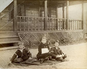  Dei same tre Archerborna (Edward, Olive og Harold) er plasserte på pledd på grusgangen utfor huset i august 1887. 