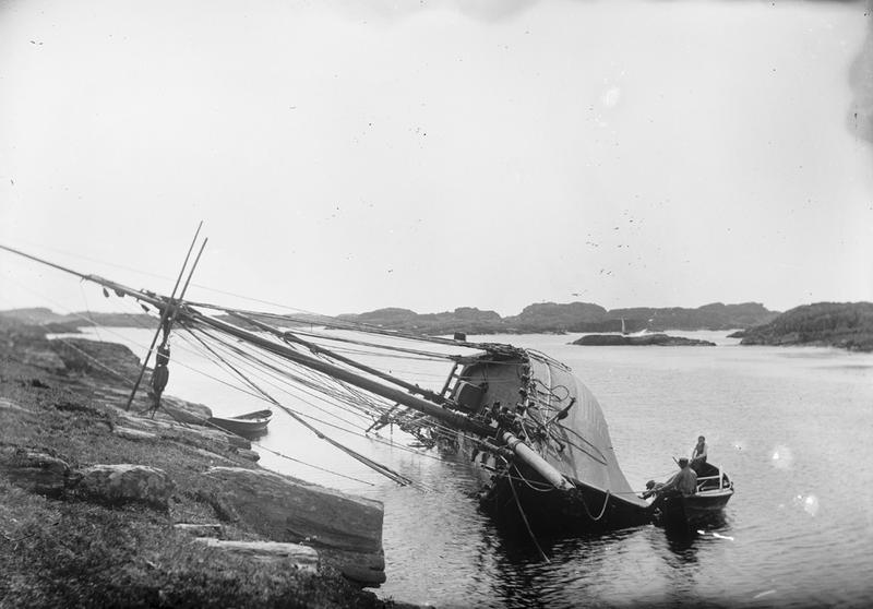  To menn i robåt kjølhaler et seilskip. Fotografiet er tatt ved Haganes, sett mot øst. Foto: Stavanger Sjøfartsmuseum, ST.S 1983-057-0157. 