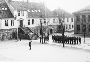 De tyske okkupasjonstroppene heiser flagg på Kongsgård skole, Stavanger 9. april 1940. Foto: Greve/ Stavanger maritime museum.