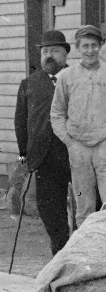 Til venstre ser vi innehaveren av dampskipsekspedisjonen, dampskipsekspeditør Jacob Fredrik de Rytter Hiorth. Mannen til høyre er ukjent. Cirka 1900. Foto: Erik Hadland Torjusen, DFF-EHT0304 (utsnitt).
